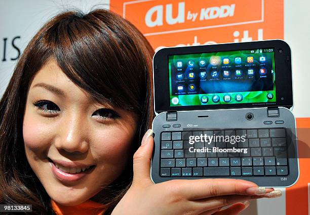 Model displays KDDI Corp.'s Sharp Corp. Manufactured IS01 smartphone running Google Inc.'s Android operating system, during the unveiling in Tokyo,...