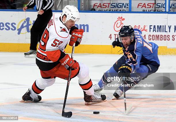 Chad LaRose of the Carolina Hurricanes carries the puck against Bryan Little of the Atlanta Thrashers at Philips Arena on March 29, 2010 in Atlanta,...