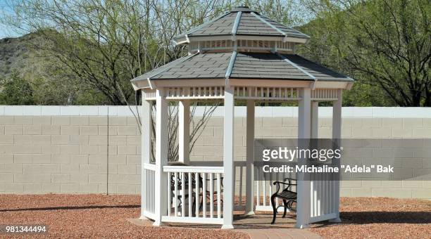 benches in gazebo and brick wall in park - gazebo stock pictures, royalty-free photos & images