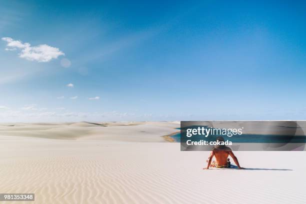 junger mann genießen den blick auf lençois maranhenses. - bundesstaat maranhão stock-fotos und bilder