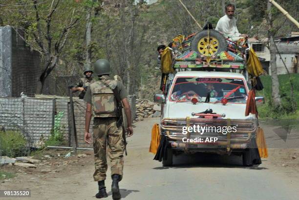 Local residents travel on a vehicle as they cross a military checkpost on the outskirts of Mingora, the capital of Swat valley on March 25, 2010. The...