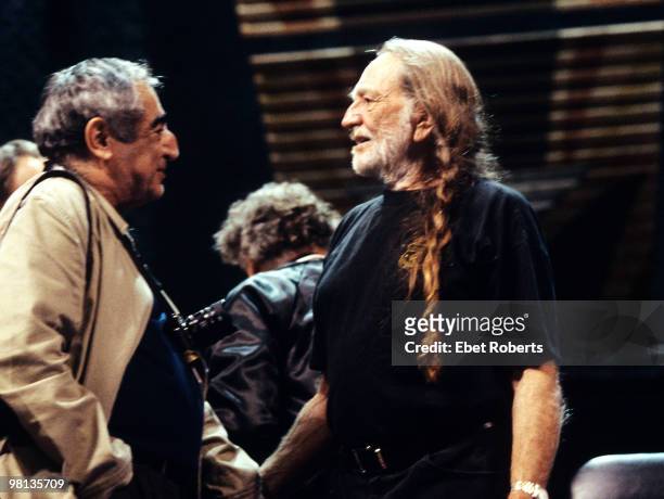 Photographer Jim Marshall talks to Willie Nelson on stage at Farm Aid on September 7, 2003 in Columbus, Ohio, United States.