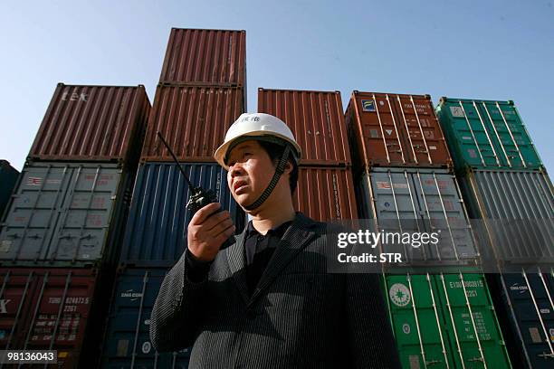 Worker monitors the loading of shipping containers at the new container port in Wuhan, in central China's Hubei province on March 27 which is...