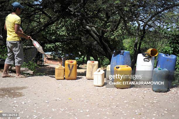 An informal petrol seller --popularly known as "pimpineros"-- awaits for customers near the border crossing between Colombia and Venezuela, in...