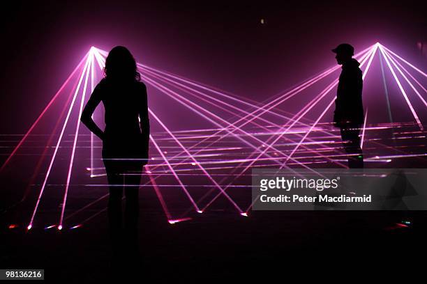 Artists pose in a laser projection entitled 'Speed of Light' at the Bargehouse on March 30, 2010 in London, England. Commissioned to celebrate the...