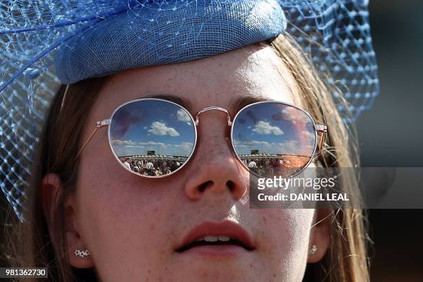 The racecourse is reflected in the sunglasses of a racegoer on day four of the Royal Ascot horse racing meet, in Ascot, west of London, on June 22,...