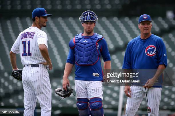 Yu Darvish, Chris Gimenez, and pitching coach Jim Hickey of the Chicago Cubs meet during a simulated game at Wrigley Field on June 20, 2018 in...