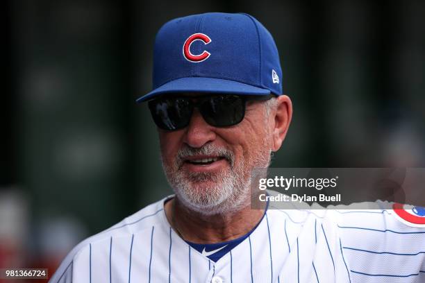 Manager Joe Maddon of the Chicago Cubs looks on from the dugout before the game against the Los Angeles Dodgers at Wrigley Field on June 20, 2018 in...