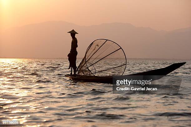 intha fisherman fishing at sunset - intha fisherman stock pictures, royalty-free photos & images