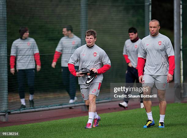 Andrey Arshavin of Arsenal walks out with team-mate Mikael Silvestre during Arsenal training ahead of their UEFA Champions League quarter final first...