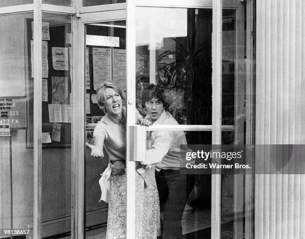 Al Pacino turns bank robber in the film 'Dog Day Afternoon', 1975. Here he pulls Penelope Allen back into the bank as she gestures wildly.