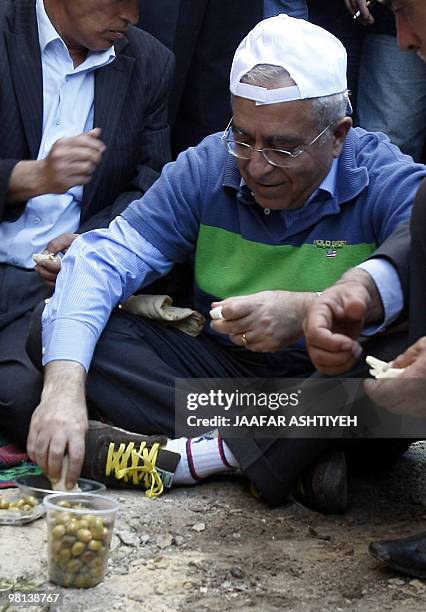 Palestinian prime minister Salam Fayyad sits on the ground and shares breakfast with villagers from Qarawa Bani Hassan near the West Bank city of...