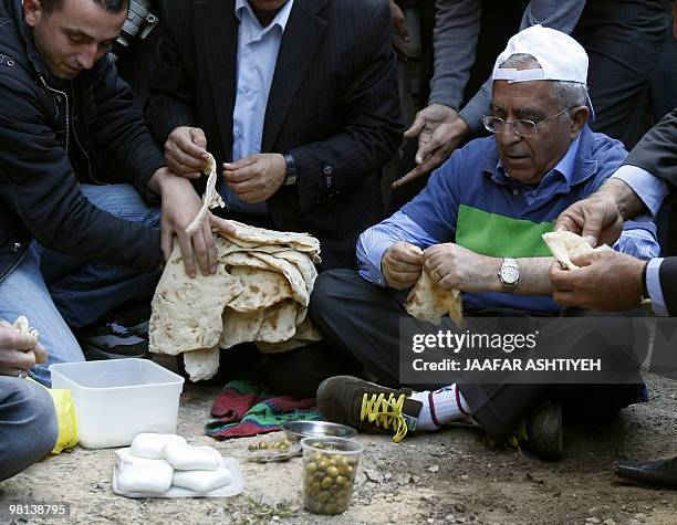 Palestinian prime minister Salam Fayyad sits on the ground and shares breakfast with villagers from Qarawa Bani Hassan near the West Bank city of...
