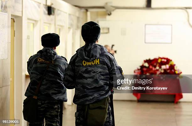 Russian police stand near a temporary plaque commemorating the victims of the terrorist metro blasts inside the Lubyanka metro station in Moscow on...
