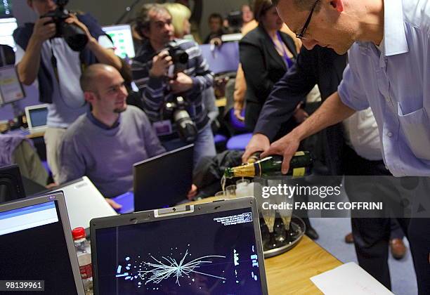 European Organization for Nuclear Research scientists celebrate with champagne reacts after the first ultra high-energy collisions at the CMS...