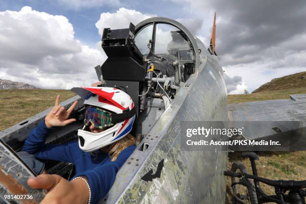 female mountain biker assumes cockpit of crashed fighter plane - fighter plane photos et images de collection