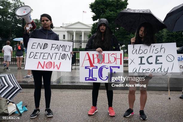 Activists hold a bullhorn and signs during a protest outside the White House June 22, 2018 in Washington, DC. Members of American Civil Liberties...