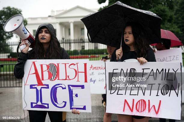 Activists hold a bullhorn and signs during a protest outside the White House June 22, 2018 in Washington, DC. Members of American Civil Liberties...