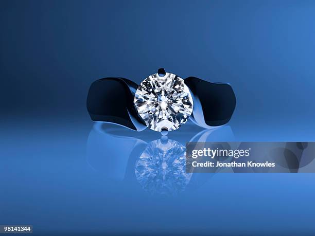 diamond ring on a blue background - gemology stock-fotos und bilder