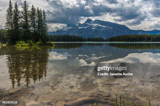mount rundle reflecting in two jacks lake, minnewanka loop, banff national park, alberta, canada - monte rundle - fotografias e filmes do acervo