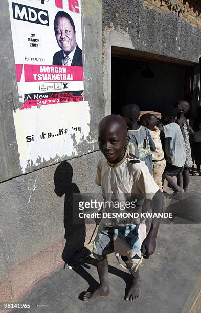 Boy passes a campaign poster of Zimbabwean opposition leader Morgan Tsvangirai in Chitungwiza 25km south of Harare on April 5, 2008. Zimbabweans are...