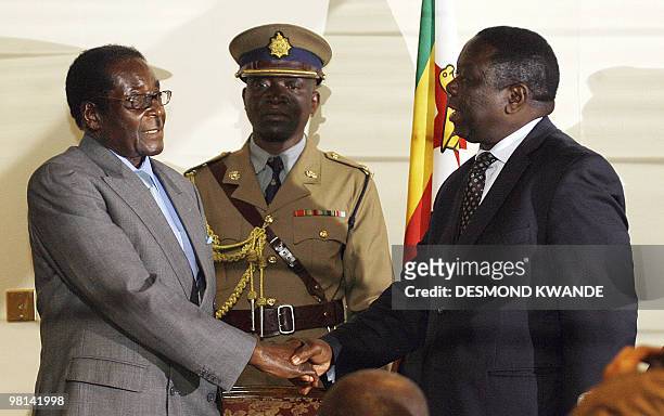 Zimbabwean President Robert Mugabe shakes hands with Movement for Democratic Change leader Morgan Tsvangirai on July 21, 2008 in Harare after the...