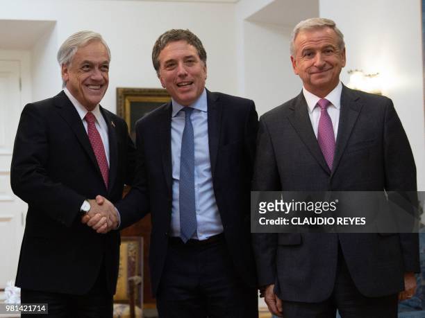 Chilean President Sebastian Pinera shakes hands with Argentina's Finance Minister Nicolas Dujovne next to Chilean Finance Minister Felipe Larrain...