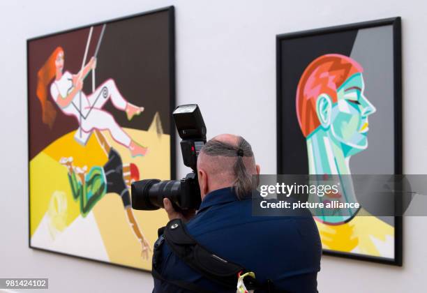 June 2018, Germany, Chemnitz: A visitor takes a picture as he stands between the two artworks 'Die Schaukel' ,and 'Dein makelloser Hals' by artist...