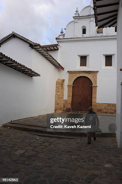 Boyacan man walks past a convent in the back street of Plaza Mayor. Villa de Leyva is a colonial town and municipality, in the Boyacá department,...