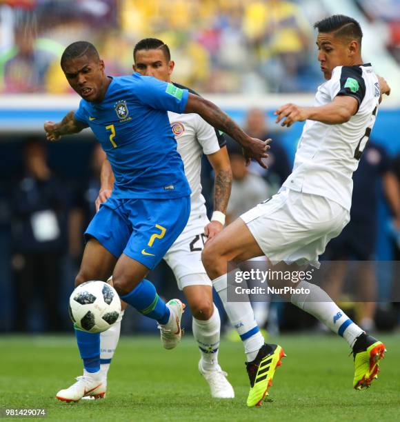 Douglas Costa of the Brazil national football team and Oscar Duarte of the Costa Rica national football team vie for the ball during the 2018 FIFA...