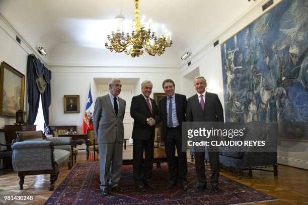 Chilean President Sebastian Pinera shakes hands with Argentina's Finance Minister Nicolas Dujovne next to Chilean Finance Minister Felipe Larrain and...