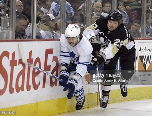 Ruslan Fedotenko of the Pittsburgh Penguins checks Garnet Exelby of the Toronto Maple Leafs into the boards at Mellon Arena on March 28, 2010 in...
