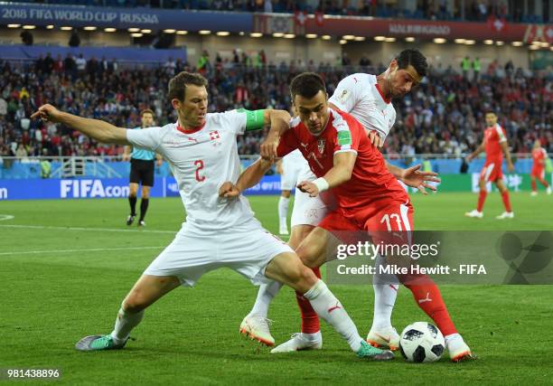 Filip Kostic of Serbia is challenged by Stephan Lichtsteiner of Switzerland during the 2018 FIFA World Cup Russia group E match between Serbia and...