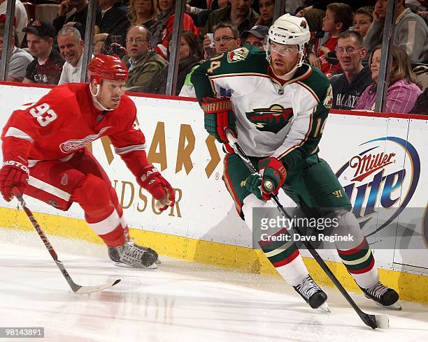 Martin Havlat of the Minnesota Wild skates with the puck in front of Johan Franzen of the Detroit Red Wings during an NHL game at Joe Louis Arena on...