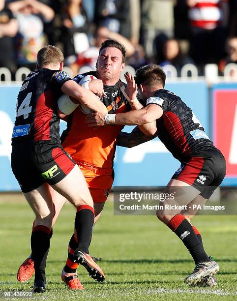 Castleford Tigers Grant Millington is tackled by Wigan Warriors Josh Woods and Oliver Gildart , during the Betfred Super League match at the...