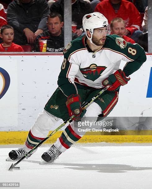 Brent Burns of the Minnesota Wild turns with the puck against the Detroit Red Wings during an NHL game at Joe Louis Arena on March 26, 2010 in...