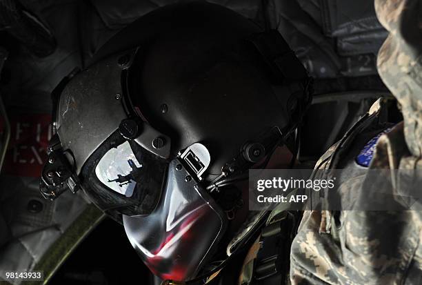 Army soldier sits onboard a military helicoopter during a flight from Camp Salerno to Forward Operating Base Sharana in Paktika province on March 30,...