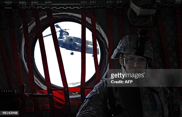 Army soldier sits onboard a military helicoopter during a flight from Camp Salerno to Forward Operating Base Sharana in Paktika province on March 30,...