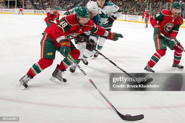 Guillaume Latendresse of the Minnesota Wild and Douglas Murray of the San Jose Sharks battle for the puck during the game at the Xcel Energy Center...