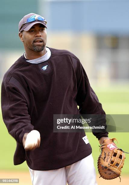 First baseman Carlos Delgado tosses a ball during spring training drills at the Toronto Blue Jays camp in Dunedin, Florida February 27, 2004.