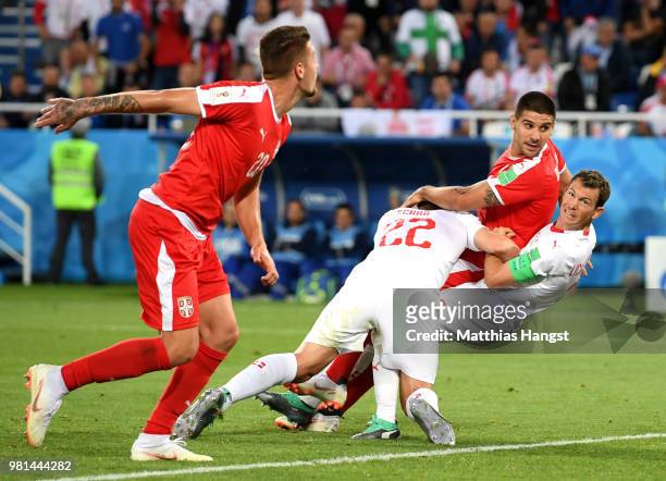 Fabian Schaer of Switzerland, Aleksandar Mitrovic of Serbia, and Stephan Lichtsteiner of Switzerland collide inside the Switzerland penalty area...