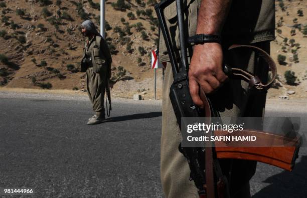 Member of the Kurdistan Workers' Party carries an automatic rifle on a road in the Qandil Mountains, the PKK headquarters in northern Iraq, on June...