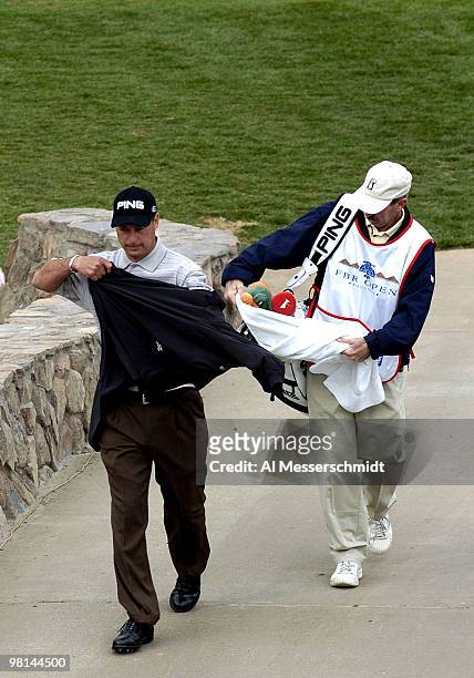 Chris DiMarco grabs a pullover after a par at the 16th hole during third round competition January 31, 2004 at the 2004 FBR Open at the Tournament...