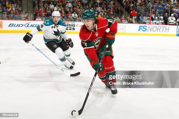 Casey Wellman of the Minnesota Wild skates with the puck while Marc-Edouard Vlasic of the San Jose Sharks defending during the game at the Xcel...