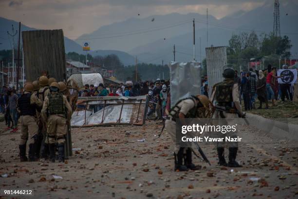 Kashmir Protesters erect tin sheets to save themselves from the metal pellets and teargas shells of Indian government forces as they throw rocks and...