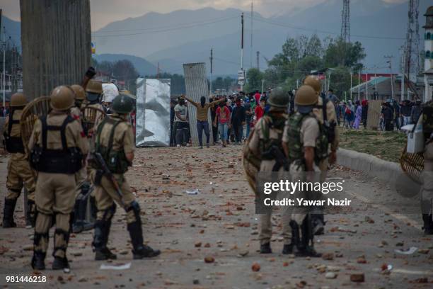 Kashmir Protesters erect tin sheets to save themselves from the metal pellets and teargas shells of Indian government forces as they throw rocks and...