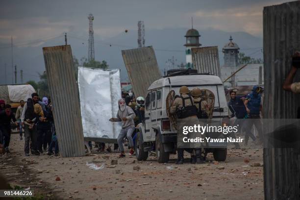 Kashmir Protesters erect tin sheets to save themselves from the metal pellets and teargas shells of Indian government forces as they throw rocks and...