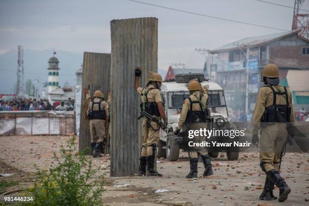 Indian police man use the confiscated tin sheets to save themselves from the bricks and stones of Kashmir Protesters during a protest on June 22,...
