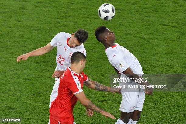 Switzerland's forward Breel Embolo and Switzerland's defender Fabian Schaer jump for the ball with Serbia's forward Aleksandar Mitrovic during the...