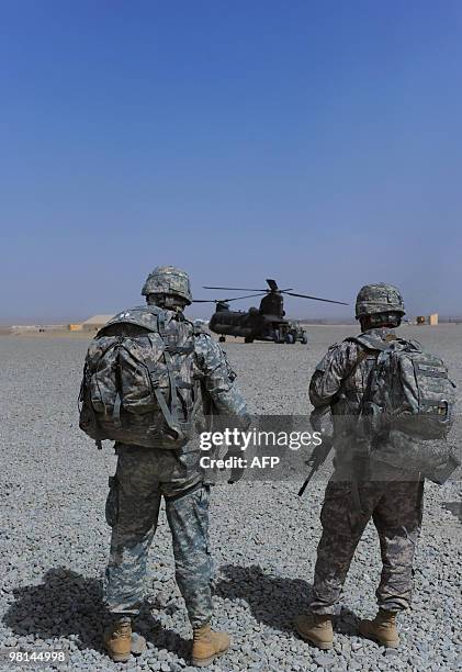 Army soldiers wait for a flight on a US military helicopter at Forward Operating Base Sharana in Paktika province on March 30, 2010. The top US...